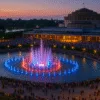 Wrocławska Fontanna Multimedialna podczas wieczornego pokazu światła i wody, ujęcie z lotu ptaka, tłum widzów wokół fontanny, Hala Stulecia w tle, lato