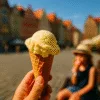 Gałka lodów waniliowych w wafelku na tle wrocławskiego Rynku z rozmytym drugim planem i dzieckiem jedzącym loda