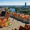 Rynek we Wrocławiu z lotu ptaka z ratuszem, kolorowymi kamienicami i widokiem na Odrę oraz Sky Tower w tle – symbole rekordów miasta
