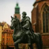 Statua jeźdźca we Wrocławiu na tle gotyckiego kościoła i kamienic