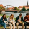 studenci jedzący tanio nad Odrą we Wrocławiu z widokiem na most i zabytki w tle