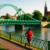 Trasa biegowa nad Odrą we Wrocławiu z widokiem na most i kościół, biegacz w czerwonej koszulce na pierwszym planie