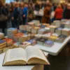 Stoiska z książkami i otwarta książka na Wrocławskich Targach Dobrych Książek – widok z bliska