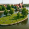 Wyspa Słodowa we Wrocławiu – widok z lotu ptaka w stylu tilt-shift, z osobami odpoczywającymi na trawie
