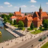 Bulwary nad Odrą we Wrocławiu w sierpniu – spacerujący turyści, zabytkowy tramwaj i rejsy statkami w słoneczny dzień