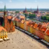 letni Rynek we Wrocławiu z kolorowymi kamienicami i ruchem turystycznym na tle Odry i kościołów