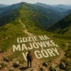 Where on a picnic in the mountains - a bird&#39;s eye view on a mountain trail with an inscription inscribed in a grassy path, in the background a wanderer and panorama of the mountain range