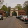 Wejście do ZOO Wrocław z tablicą ZOO i parkingiem samochodowym