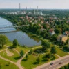 Widok na Park Miejski i most w Brzegu Dolnym z amfiteatrem, placem zabaw i panoramą zakładów przemysłowych w tle