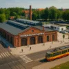 Centrum Historii Zajezdnia Wrocław – budynek z czerwonej cegły, tramwaje i plac przed muzeum z odwiedzającymi