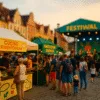 stoiska z kuchnią roślinną i fermentowaną podczas festiwalu kulinarnego, wieczorna atmosfera, scena z koncertem na tle europejskiej zabudowy