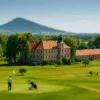 pałac w Krobielowicach z polem golfowym na pierwszym planie i Ślężą w tle, widok z lotu ptaka latem