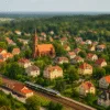 Oborniki Śląskie z lotu ptaka – kościół, domy i pociąg z Wrocławia wśród zieleni