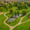 Staw, plac zabaw i altana w Parku Brochowskim otoczone alejkami i drzewami – idealne miejsce na spacer i odpoczynek we Wrocławiu
