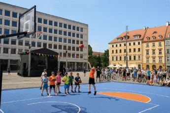 Dzieci grające w koszykówkę na placu Nowy Targ podczas miejskiego wydarzenia sportowego we Wrocławiu – turniej z udziałem gwiazd, konkursy i animacje