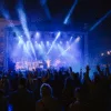 Wieczorny koncert uwielbienia na Placu Wolności we Wrocławiu – tłum z podniesionymi rękami, scena oświetlona niebieskimi reflektorami, 50-osobowy chór na scenie