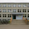 Szkoła Podstawowa nr 61 we Wrocławiu – widok frontalny z rowerami przed wejściem głównym i betonowym chodnikiem