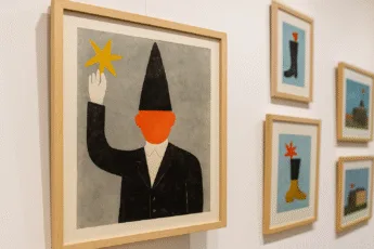 Wystawa grafik w Centrum Kultury Nowy Pafawag – plakat z sylwetką w czarnym stroju i pomarańczową twarzą na tle szarym, obok inne ilustracje w ramkach