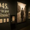 Wnętrze wystawy „1945. Czy to jest wolność?” w Muzeum Pana Tadeusza – ściana z dużym napisem, archiwalnymi plakatami i zdjęciami oraz sylwetką mężczyzny idącego przez zniszczone miasto