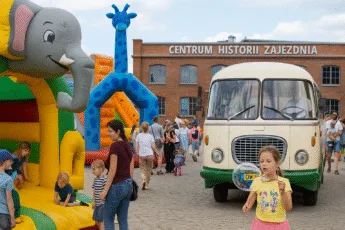 Rodzinny festyn przy Centrum Historii Zajezdnia we Wrocławiu z dmuchańcami, zabytkowym autobusem Jelcz i dziećmi puszczającymi bańki mydlane