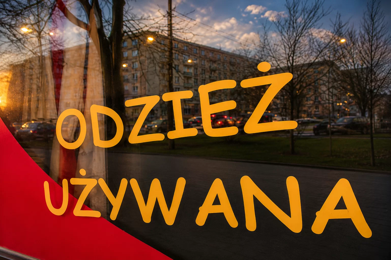Napis Odzież Używana na witrynie sklepu z odzieżą z drugiej ręki