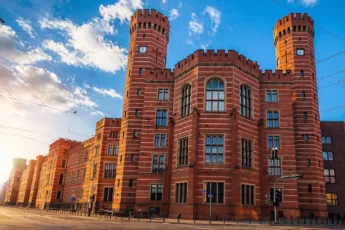 Sąd Okręgowy we Wrocławiu w słoneczny dzień z charakterystyczną ceglaną fasadą i wieżami